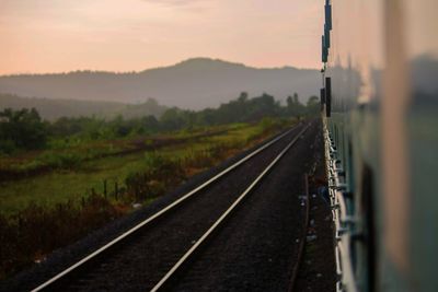 Railroad tracks against sky during sunset