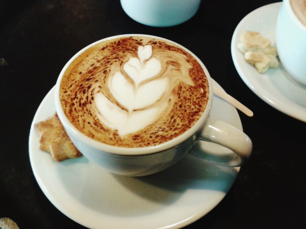 COFFEE CUP WITH CAPPUCCINO AND SPOON ON TABLE