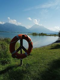 Bicycle by lake against sky