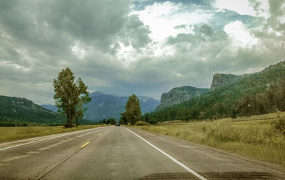 Empty road with trees in background
