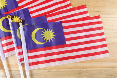 Directly above shot of malaysian flags on wooden table