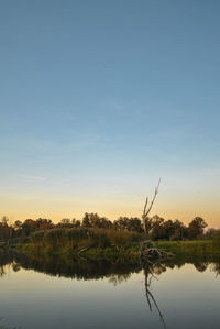 Scenic view of lake against sky at sunset