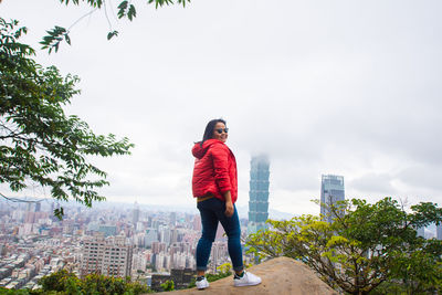 Woman standing against sky in city