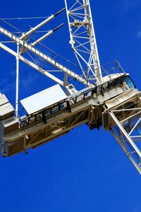 Low angle view of ferris wheel against clear blue sky