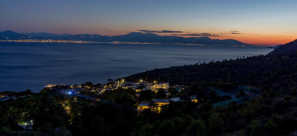 Scenic view of sea by town against sky during sunset