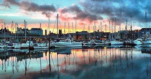 Boats in harbor at sunset