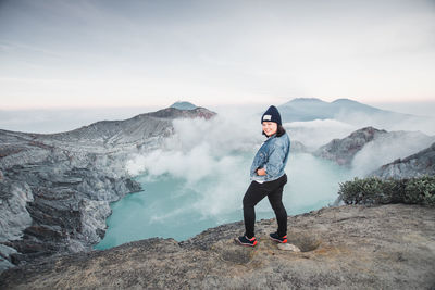 Full length portrait of woman standing on mountain