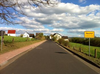 Empty road against cloudy sky