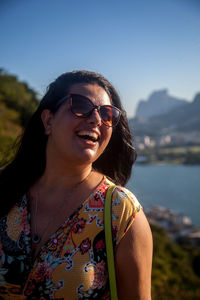 Smiling mid adult woman against sky