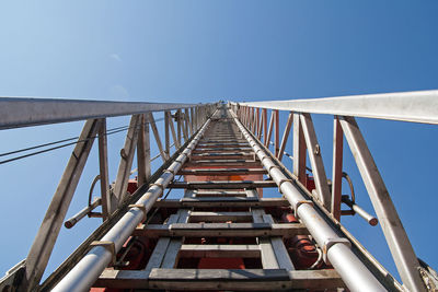 Low angle view of footbridge against clear blue sky