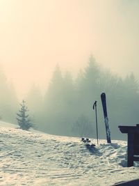Scenic view of foggy mountain and ski against during winter