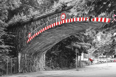 Road sign on bridge against trees