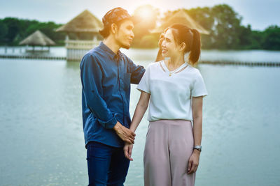 Smiling couple standing by river