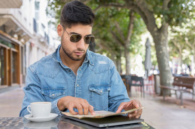 Young man wearing sunglasses at cafe table