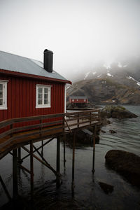 House by buildings against sky during winter