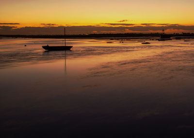 Boat sailing in sea against sky during sunset