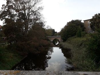 Arch bridge over river against sky