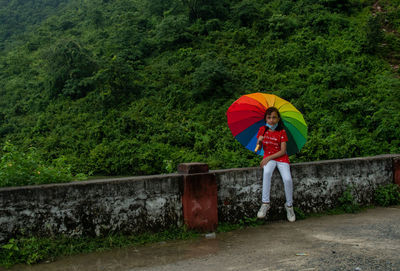 Rear view of woman holding umbrella