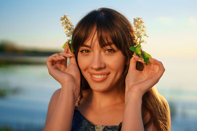 Portrait of a young woman holding flowers near her face