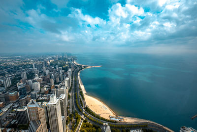 High angle view of buildings by sea against sky