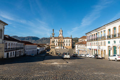 View of street amidst buildings against sky in city