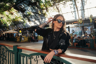 Young woman wearing sunglasses while standing outdoors