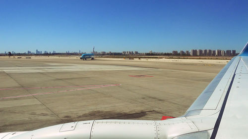 Airplane on runway against clear blue sky