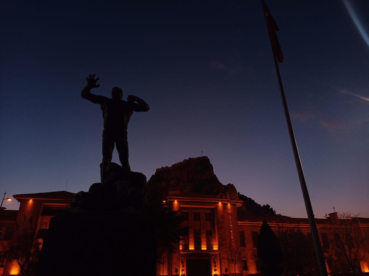 LOW ANGLE VIEW OF STATUE AGAINST SKY AT SUNSET