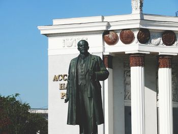 Low angle view of statue against building against clear sky