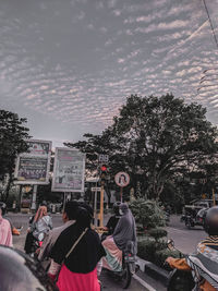 People on street in city against sky