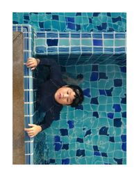 High angle portrait of smiling woman in swimming pool