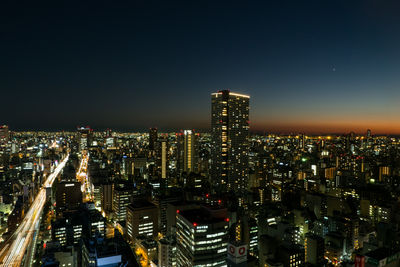 Illuminated cityscape against sky at night