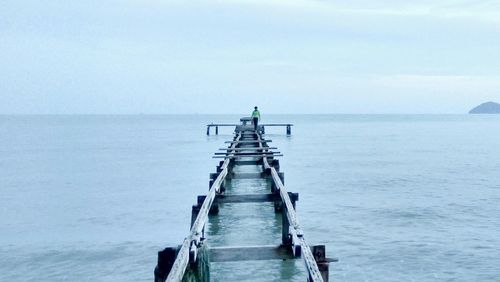 View of jetty in sea against clear sky