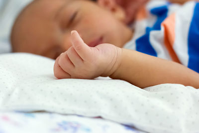 Close-up of baby sleeping on bed