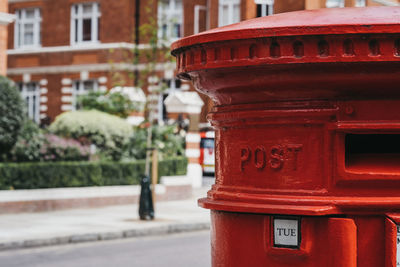 Close-up of red mailbox on city street