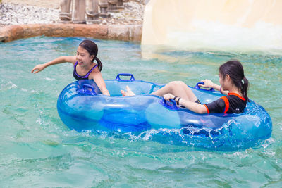 Friends enjoying with inflatable ring in swimming pool