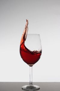 Close-up of wineglass on table against white background