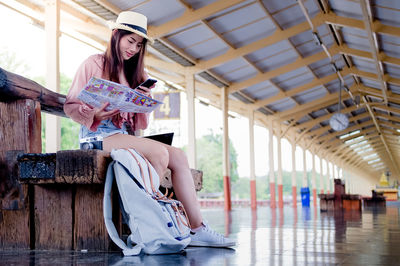 Young woman wearing hat sitting outdoors