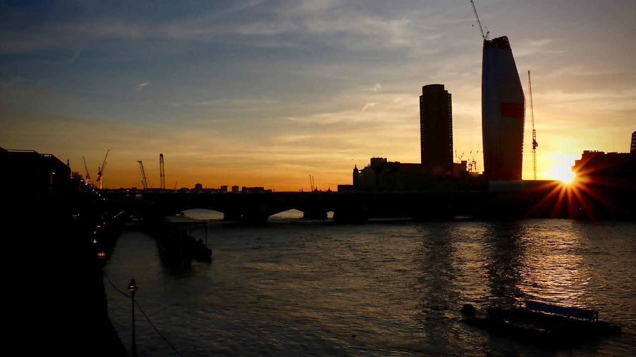 BRIDGE OVER RIVER AGAINST SKY AT SUNSET