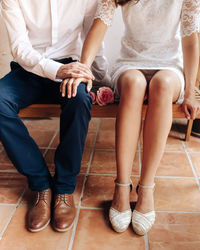 Low section of couple siting on bench