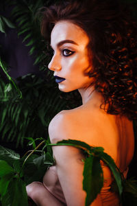 Beautiful redhead woman wearing make-up by plants