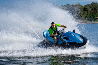 Young man riding jet ski in sea