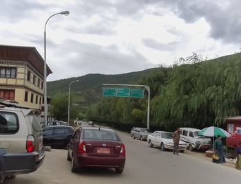 Cars parked on street in city against sky