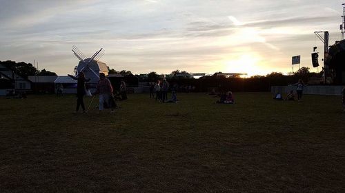 People in town square against sky during sunset