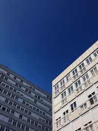 Low angle view of buildings against clear blue sky