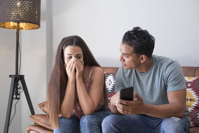 Young couple sitting on mobile phone