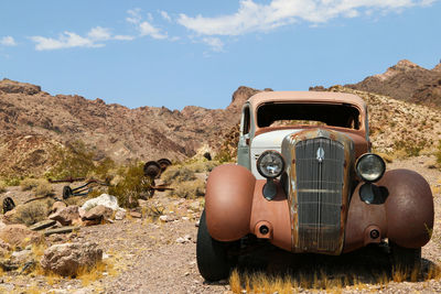 Vintage car on landscape against sky