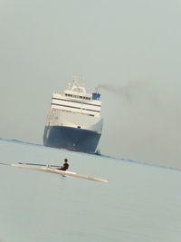 Man sailing on boat in sea against sky