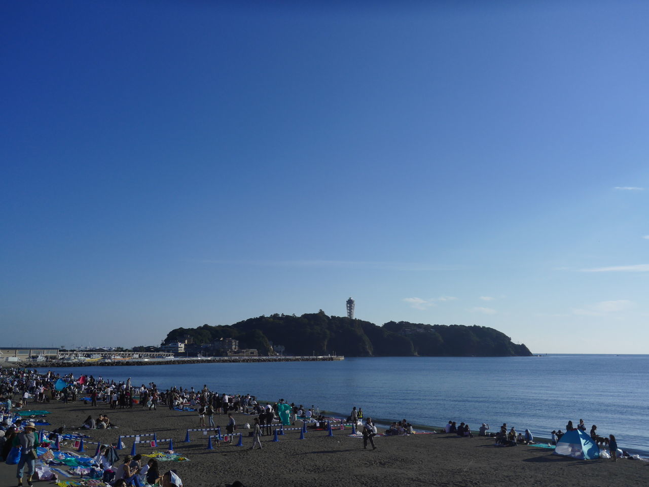 large group of people, beach, water, sea, blue, copy space, vacations, shore, sand, mixed age range, tourist, travel, leisure activity, tourism, crowd, clear sky, summer, ocean, weekend activities, coastline, nature, tranquility, sky, calm