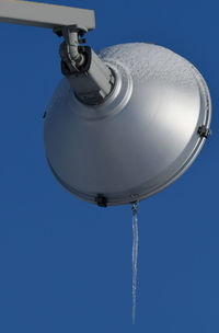 Low angle view of security camera against clear blue sky